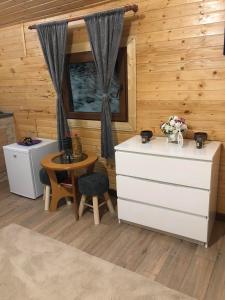 een kamer met een tafel en een dressoir in een hut bij Roua Muntelui in Cîmpu lui Neag