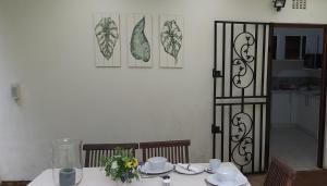 a table with plates and cups and a vase on it at Cybele Lodge Boutique Bed and Breakfast in Hillcrest