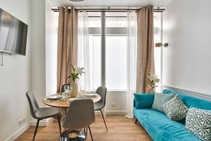 een woonkamer met een blauwe bank en een tafel bij NEWLY RENOVATED ! Stunning 2BR Apt in the Heart of Paris 15 in Parijs