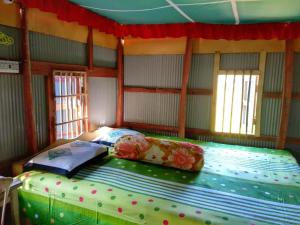 een groot bed in een kamer met ramen bij Sawpnorajjo Park & Resort in Kuakata