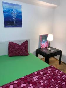 1 dormitorio con cama verde y mesa con lámpara en UniriiCC, en Bucarest