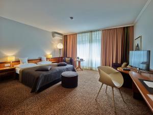 ギーセンにあるホテル タンドレアスのベッド1台、薄型テレビが備わるホテルルームです。