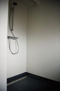 een badkamer met een douche in een witte muur bij De Slaapmuts in Winsum