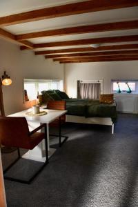 een slaapkamer met een bed en een tafel in een kamer bij De Slaapmuts in Winsum