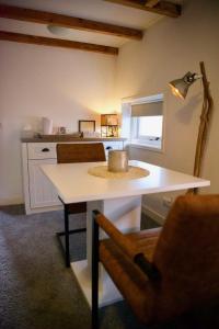 een keuken met een witte tafel en een stoel bij De Slaapmuts in Winsum