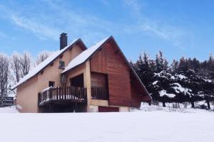 a house with a snow covered roof in the snow at Gîte Granit des Fraux in Besse-et-Saint-Anastaise