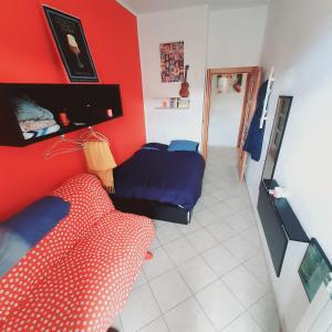 a room with a red wall with a bed and a mirror at Cozy ROOM STANZA close city center in a family House Stanza in appartamento condiviso noi viviamo in casa STANZA in affitto in Turin