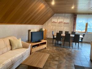 a living room with a couch and a tv and a table at Ferienhaus Nicole in Piesport