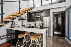 ヒューストンにあるQuantum Tiny Loft at East End Revitalizedのキッチン(白いカウンター、スツール付)