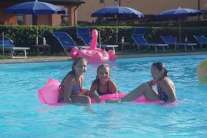 três raparigas sentadas em insufláveis numa piscina em Podere San Giuseppe em San Vincenzo