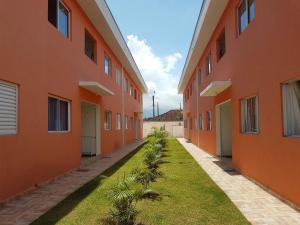 an empty courtyard of an orange building with grass at Ap23 Cristal do Indaiá I 450m praia in Bertioga