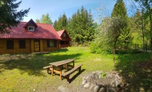 a picnic table in a yard next to a cabin at Zacisze in Kukle