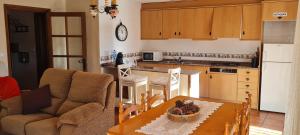 a kitchen with a table and a living room at Apartamento Rural Coll d'Ares in Ares del Maestre