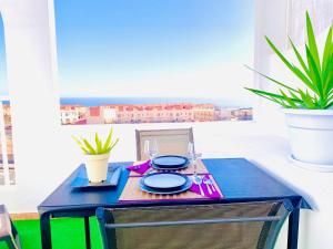 a blue table with plates and glasses on it at NEW Studio Bonito Amanecer, Swiming Pool,WiFi, Sun Terrace in Caleta De Fuste