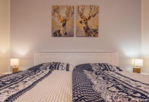 1 dormitorio con 2 fotografías de ciervos en la pared en Apartmán Pod borovicí, en Kovalovice