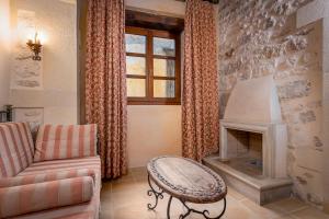 a living room with a couch and a fireplace at Palazzino Di Corina in Rethymno Town