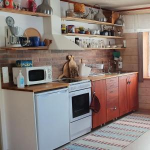 een keuken met een fornuis en een magnetron bij Stallet B&B in Köping