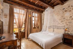 a bedroom with a bed with a mosquito net at Palazzino Di Corina in Rethymno