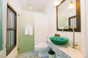 un bagno con lavandino, water e specchio di The Memory at On On Hotel a Phuket Altre 37 foto