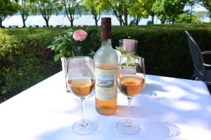 Una botella de vino y dos copas en una mesa. en Iris am See garni, en Radolfzell am Bodensee