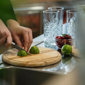 a person cutting limes on a cutting board with a knife at B&B La Siesta in Markovci