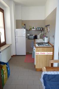 a kitchen with a white refrigerator and a sink at Appartamento Masi in Lasino
