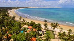 een luchtzicht op een strand met palmbomen en de oceaan bij Pousada Les Alizes in Icaraí