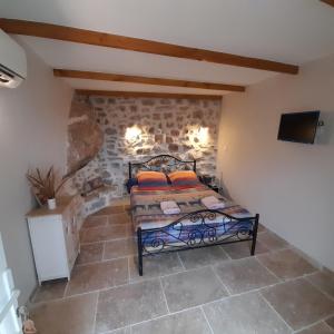 a bedroom with a bed in a stone wall at L'Auberge du Mazet in Lodève