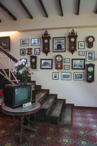 a room with a tv and a staircase with clocks at The Memory at On On Hotel - SHA Extra Plus in Phuket