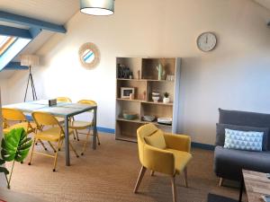 ein Wohnzimmer mit Tisch und Stühlen und einer Couch in der Unterkunft Grand et Charmant 3 pièces Breton Saint Brieuc Centre in Saint-Brieuc