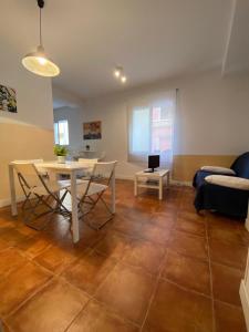 sala de estar con mesa, sillas y sofá en Centro + wifi+ 2 camas de matrimonio +playa, en Cádiz