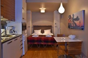 a small room with a bed and a kitchen at Levi Suites Levin Klubi in Levi