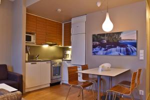 a kitchen with a table and chairs and a refrigerator at Levi Suites Levin Klubi in Levi