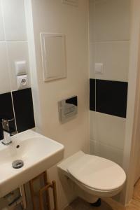 a bathroom with a white toilet and a sink at Apartament Szczecin Kobalt - Wyzwolenia in Szczecin