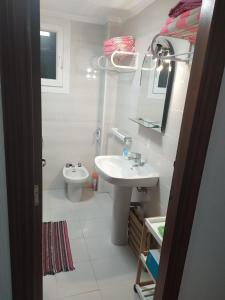 uma casa de banho branca com um lavatório e um WC em APARTAMENTO con BUENA VISTA em Torrevieja