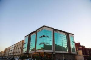 أرتو للشقق الفندقية في الرياض: مبنى زجاجي فيه سيارات تقف امامه