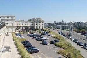 a parking lot full of cars in a city at Thermae Palace in Ostend