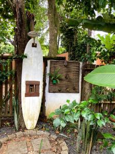 a surfboard leaning against a fence with a bird house at Pousada Vilarejo in Itacaré