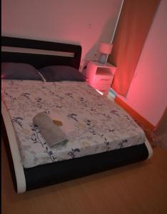 ein Schlafzimmer mit einem Bett mit einer Decke und einer Lampe in der Unterkunft Delux Appartment in Praia