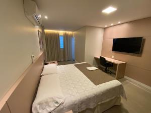 um quarto de hotel com uma cama e uma secretária em Hotel Marajó em Uberlândia