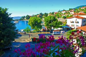 a view of a town with a river and flowers at Apartmani Senka in Ika