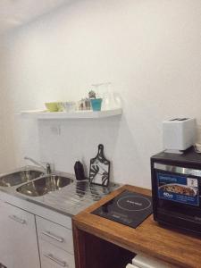 a kitchen with a sink and a microwave at Cabañas Aire Fresco in Mar del Plata