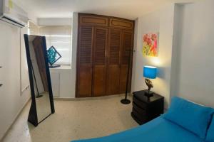 1 dormitorio con 1 cama azul y 1 lámpara azul en Oferta frente a la playa Cartagena . En, Sp, It. en Cartagena de Indias