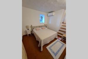 - une petite chambre avec un lit et un escalier dans l'établissement Casa Mariu' ,con giardino vista mare, à Liscia di Vacca