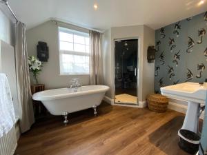 a bathroom with a bath tub and a sink at No 22 in Barnstaple
