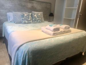 1 dormitorio con 1 cama con toallas en Hotel Berlin Pinamar en Pinamar