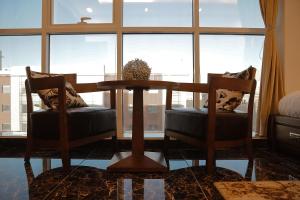 a dining room with a table and two chairs and a window at Arto Aparthotel in Riyadh