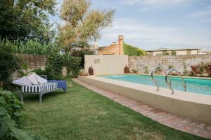 a pool in a yard with a bench next to it at Versión Moreno B & B in General Villegas