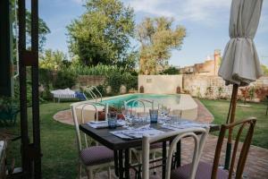 a table with wine glasses on it next to a pool at Versión Moreno B & B in General Villegas