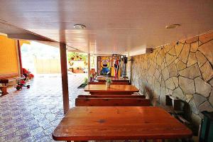 a row of benches in a room with a stone wall at Guest house Ameliya in Vardane